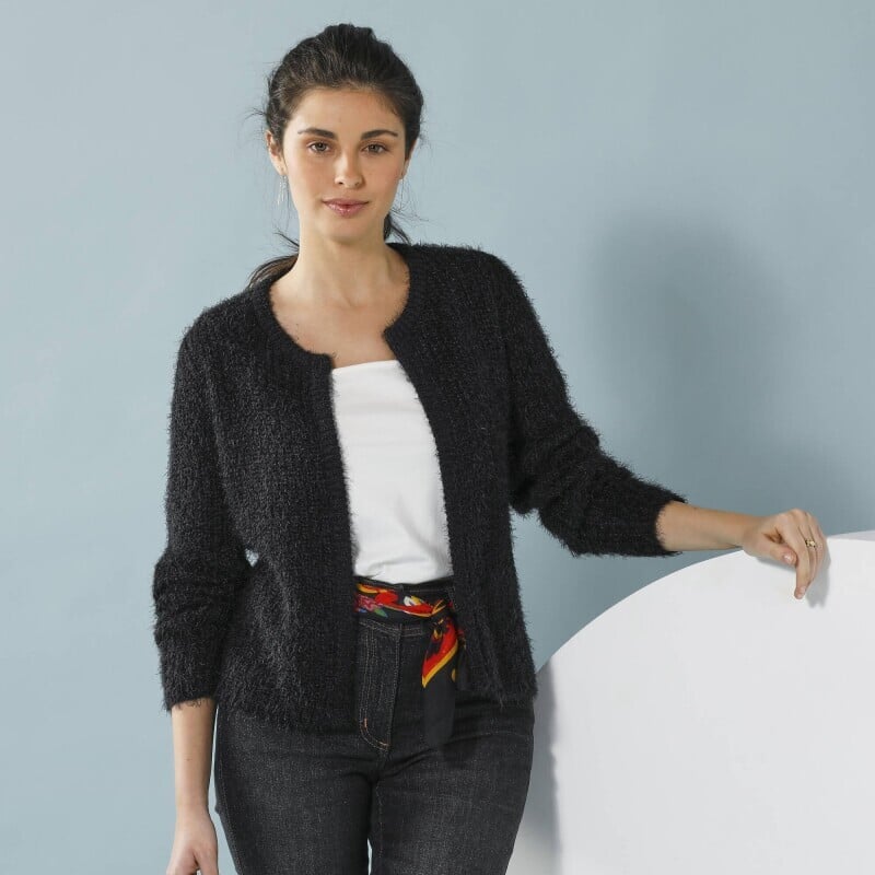 Un cardigan scurt pentru o siluetă minionă, confecționat dintr-un material pufos tricotat.